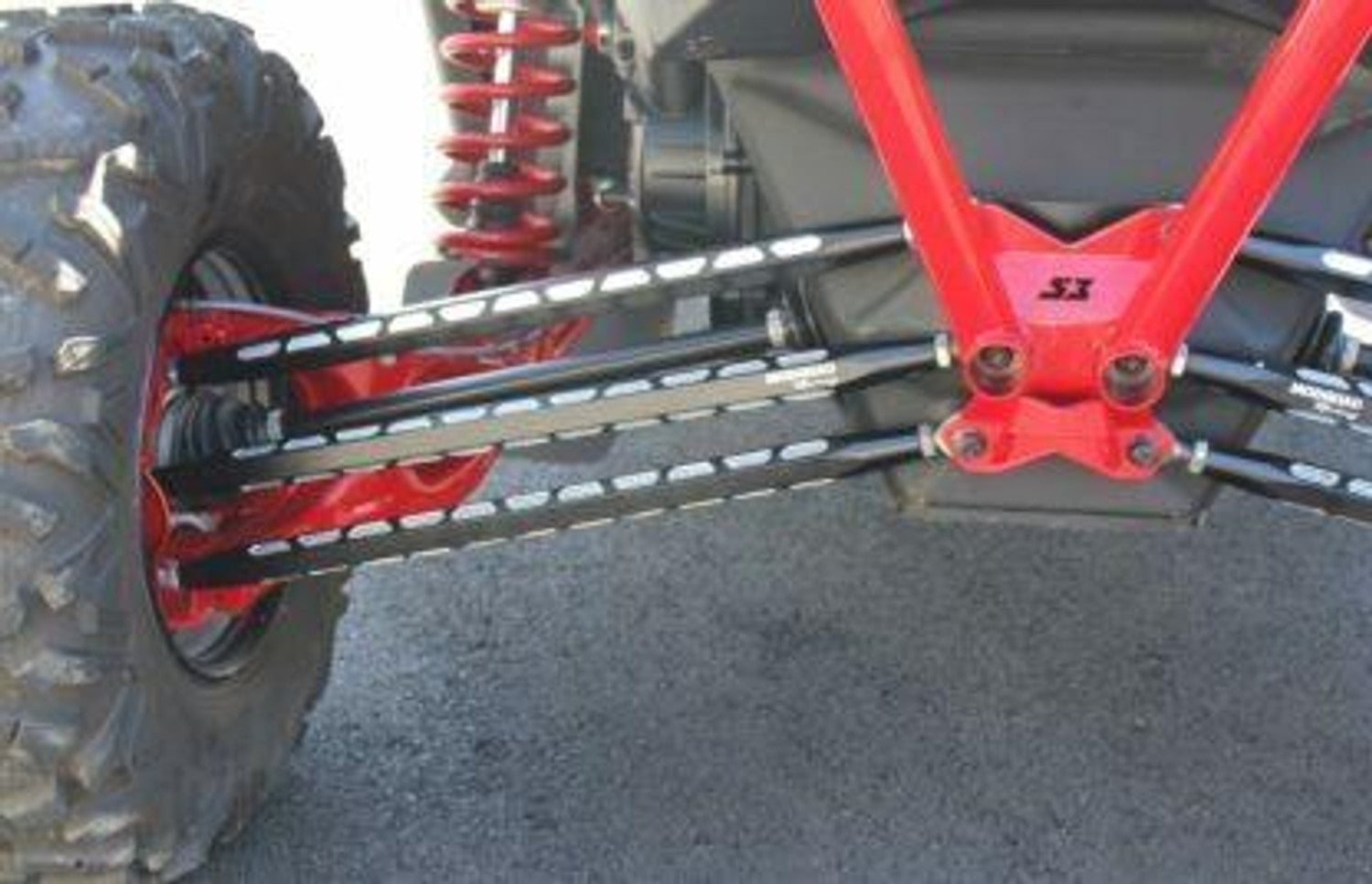 Close-up of ModQuad Racing Can-Am Maverick X3 rear radius rods in black with red accents on off-road vehicle.